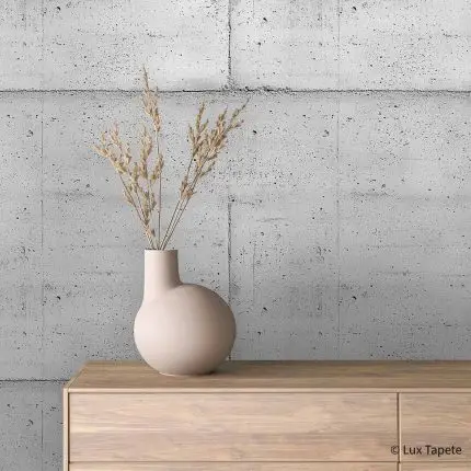 Samolepljiva tapeta beton sa tragovima oplate na reljefnoj foliji iza komode od svetlog drveta sa keramičkom vazom