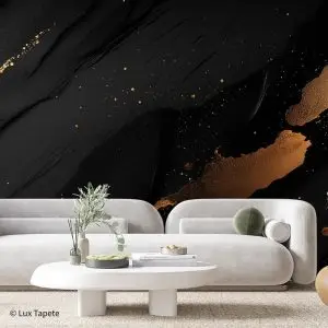 Modern living room with a white curved sofa, round coffee table, and a bold black-and-gold abstract mural wall nearby.