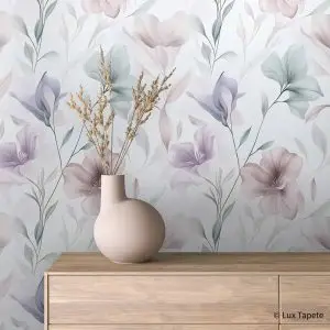 Pebble-pink vase with dried grasses on a wooden dresser against pastel floral wallpaper with soft lavender and blush tones.